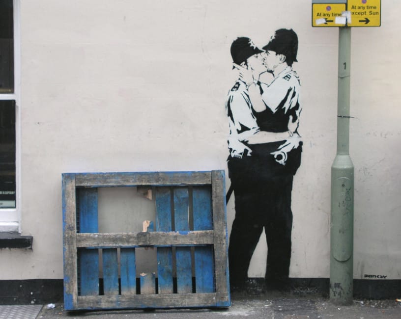 Banksy Kissing Coppers mural symbolizing non-attachment, identity disruption, and expanded influence