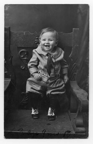 Vintage black-and-white photograph of a smiling infant symbolizing early childhood before subconscious transformation