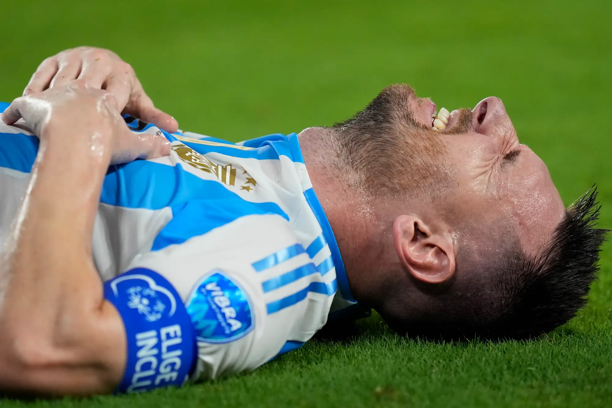 Lionel Messi lying on the pitch in pain after international defeat, embodying setback, perseverance, and inner resolve.”