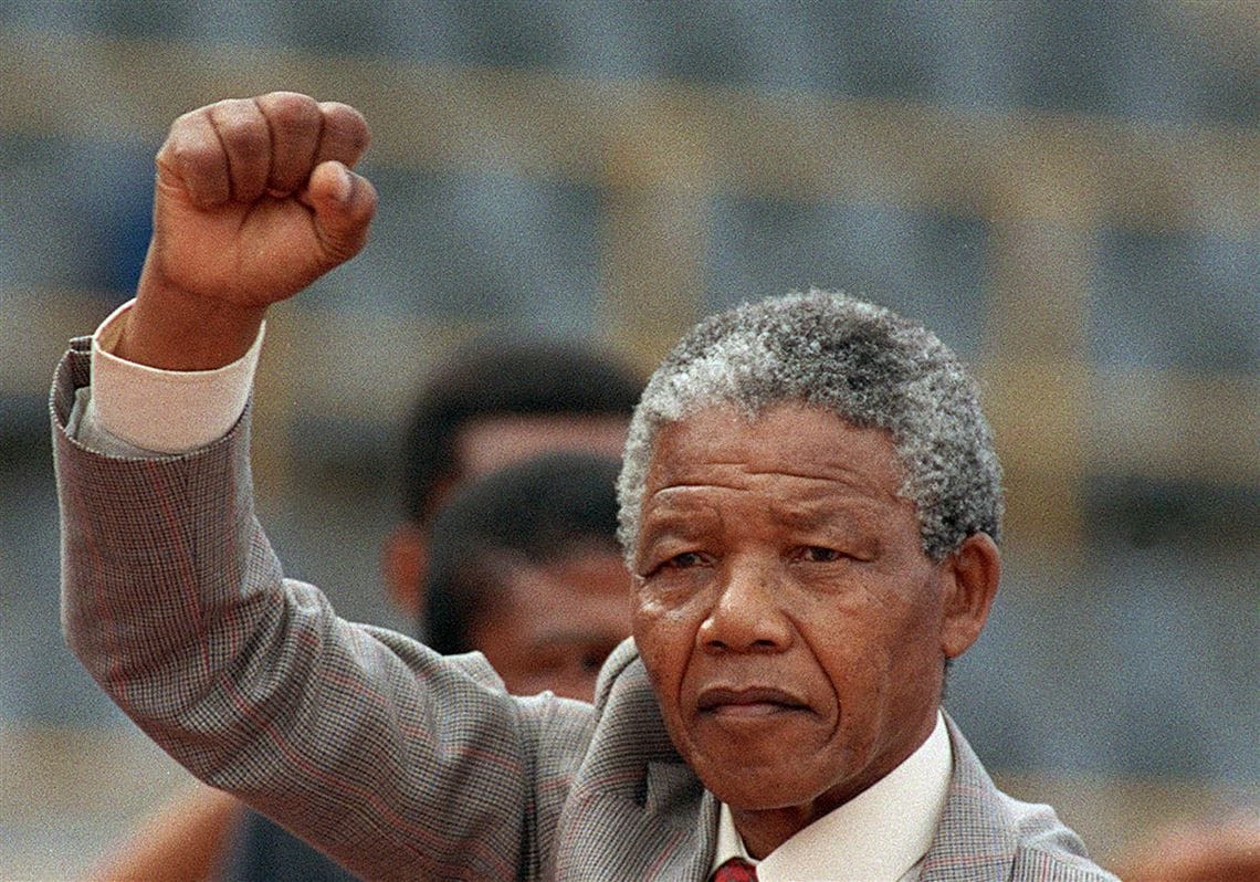 Nelson Mandela raising his fist in a gesture of resolve, dignity, and moral authority