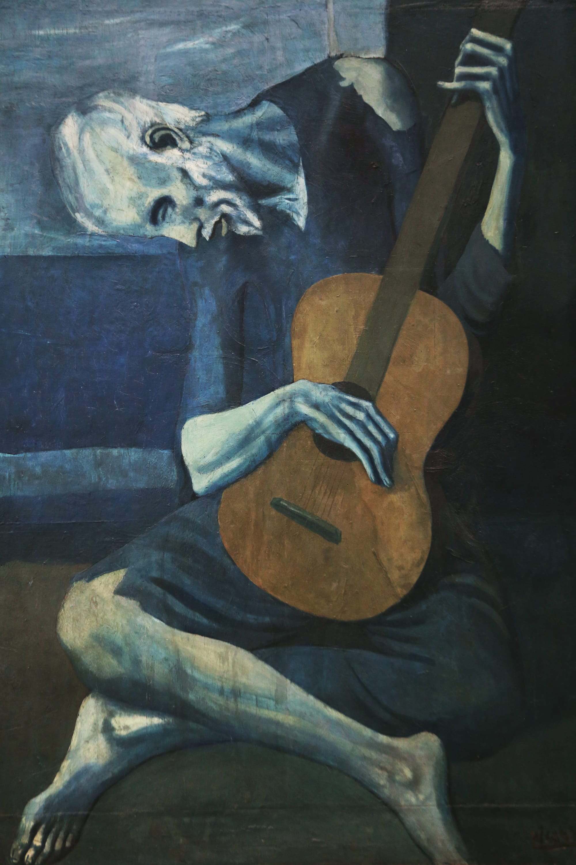 Pablo Picasso The Old Guitarist from his Blue Period, expressing sorrow, tenderness, and emotional truth through restrained blue tones