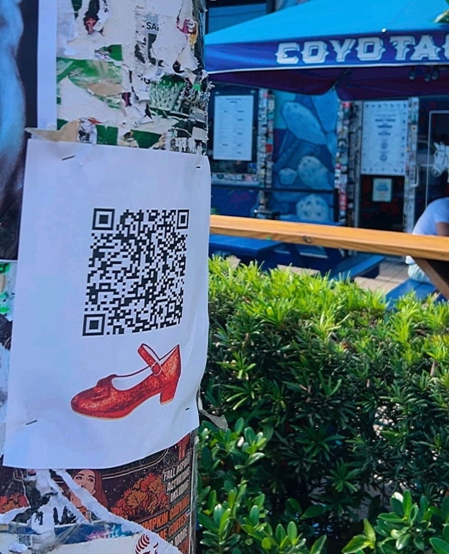 Red Dorothy slippers QR code poster spotted on a Wynwood street pole — a real-life synchronicity and street-magic moment from The Universe Unveiled.