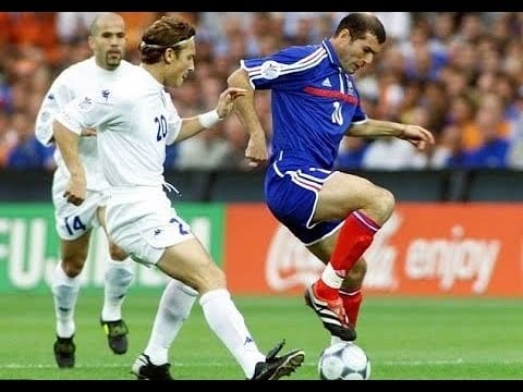 Zinedine Zidane calmly controlling the ball while defenders commit, demonstrating stillness, balance, and intelligent movement.