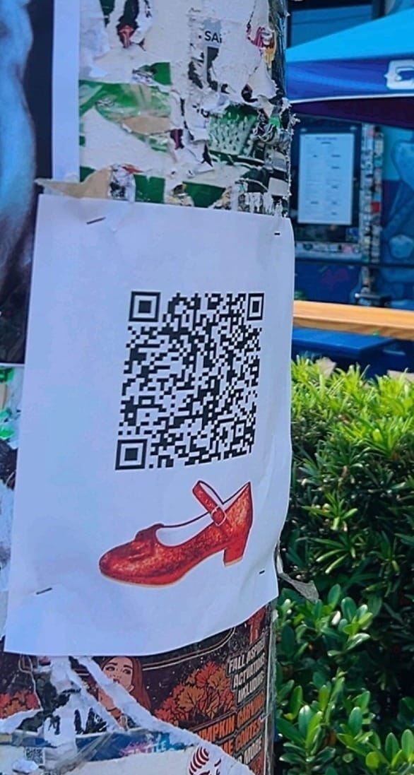 Red shoes QR code poster attached to a street pole in Wynwood, Miami as part of a public installation