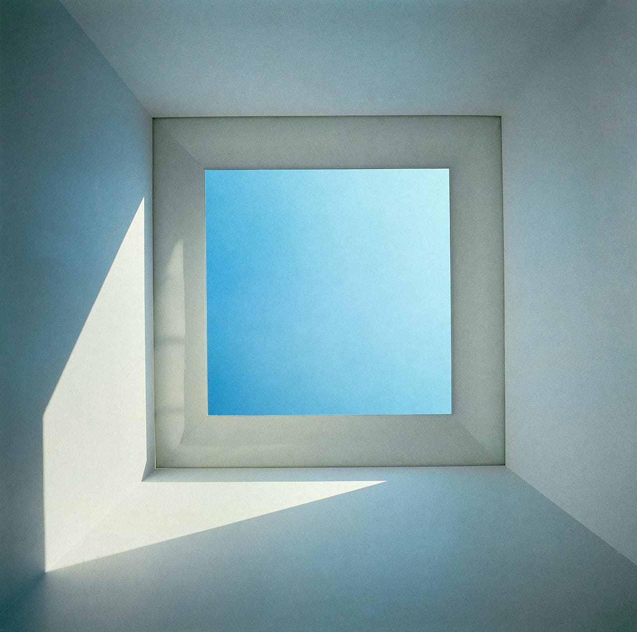 Installation by James Turrell featuring a ceiling opening framing the sky, altering perception through light and space