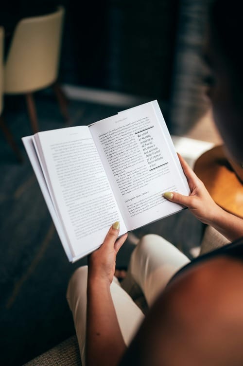 A serene woman reading a book, symbolizing inner wisdom, self-discovery, and the quiet power of subconscious reprogramming.