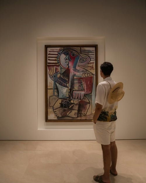 Man in a museum absorbing a Picasso painting—channeling Picasso energy