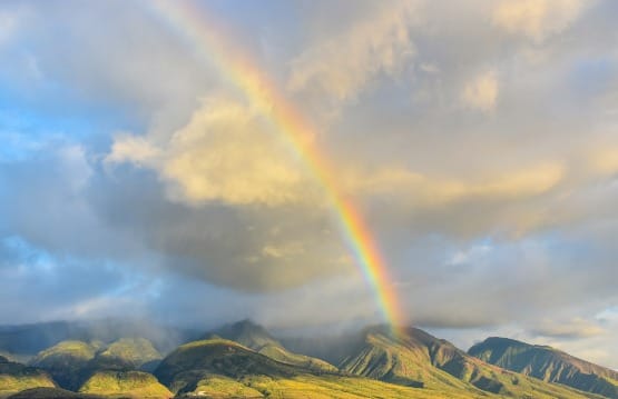 Rainbow over green mountains representing Abraham Hicks’ Emotional Guidance Scale—the rise from darker emotions to light and clarity.