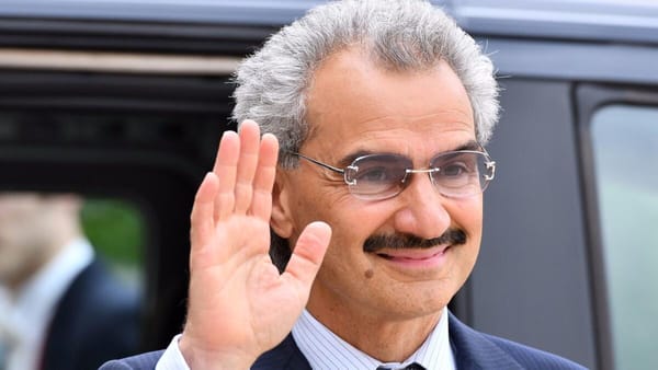 Prince Alwaleed bin Talal greets the crowd, reflecting a calm, manifestor’s presence.