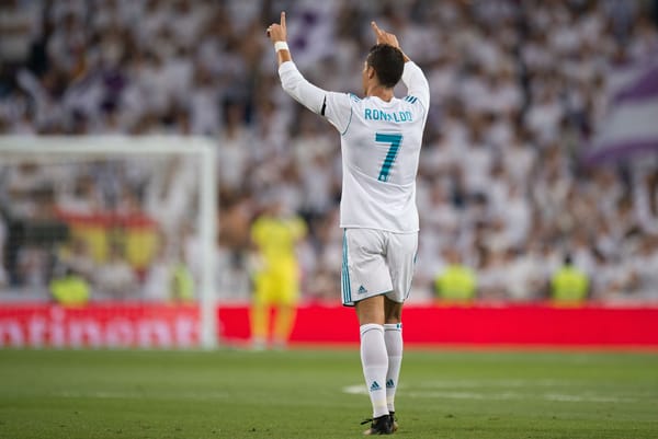 Cristiano Ronaldo standing on the pitch with arms raised, embodying inevitability and identity assumed before results
